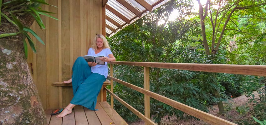 Sitting outside the treehouse at Roland Rumm's Garden Guesthouse reading