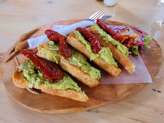 Smashed Avocado on Sourdough with Sun-Dried Peppers and salad and Tshilli's Hot Pepper Sauce