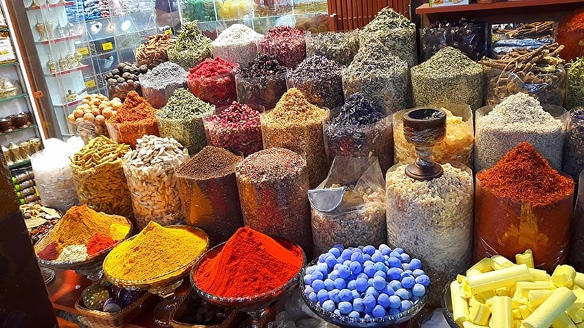 Jars and dishes of different spice with yellow, gold and red at the front, a must on your 7 day Dubai Itinerary
