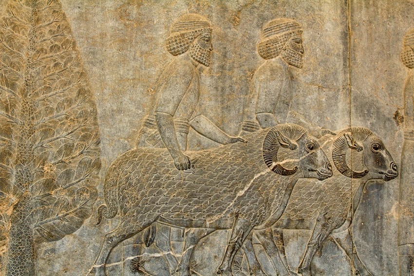 Bas relief of two bearded shepherds with two rams with a tree on the left hand side