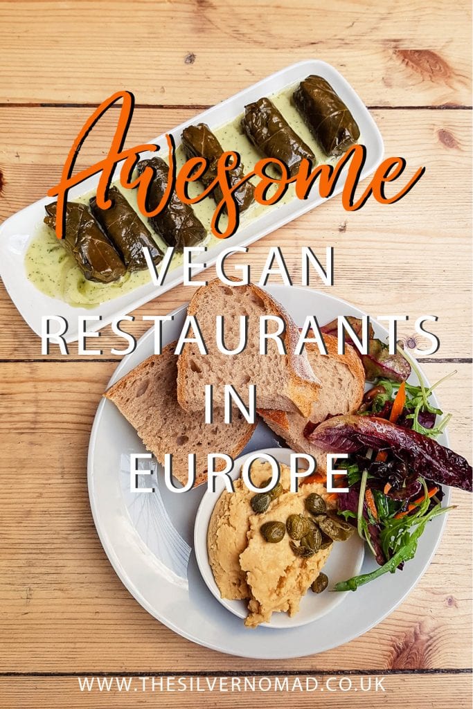 Dishes of vegan food including wrapped vine leaves on a slim white rectangular dish and salad, bread on a white round plate with humous in a white bowl. Writing "Awesome vegan restaurants in Europe" superimposed on top