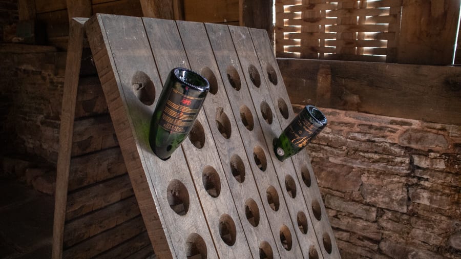 two empty bottles of sparkling wine stored in a wooden bottle holder