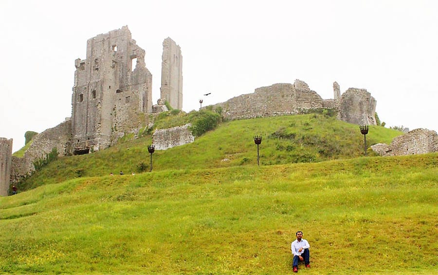 Ruins of Corfe Castle with green sloping grass lawns
