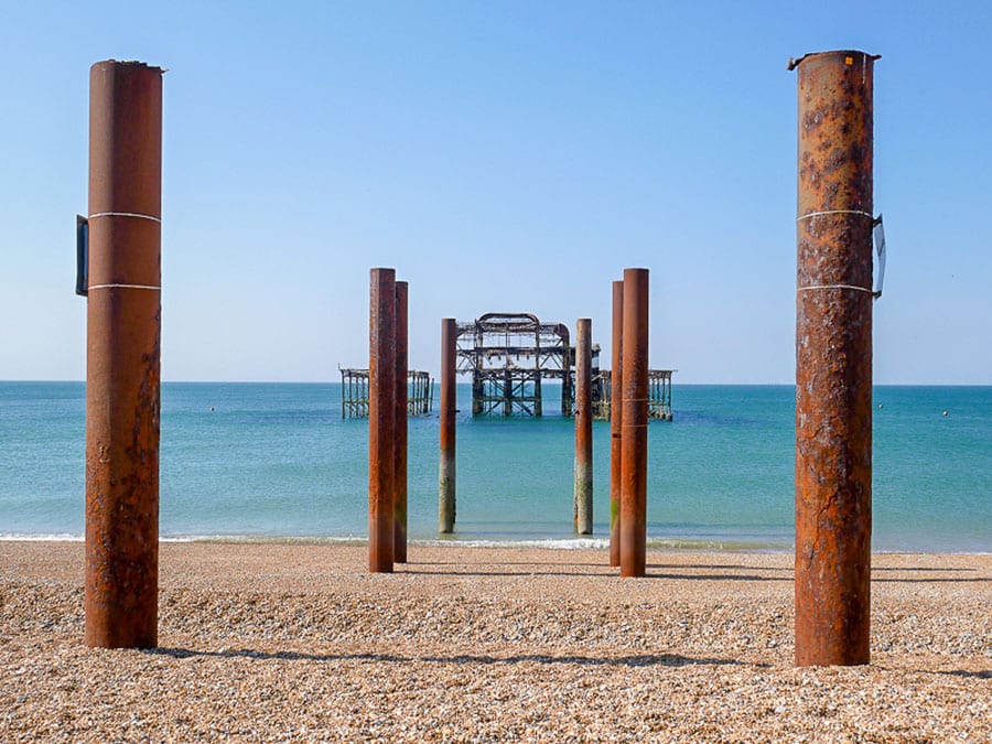 pairs of rusting iron posts leading into the sea