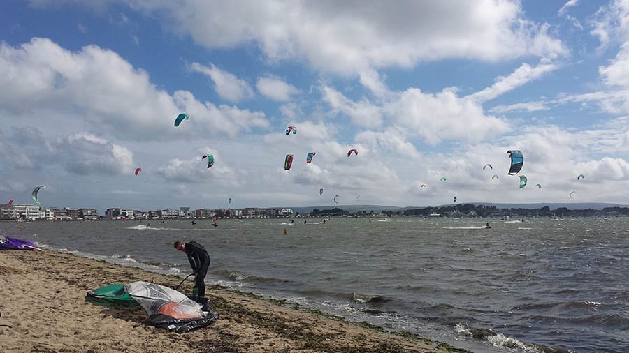 sky over Poole beach filled with kitesurfers