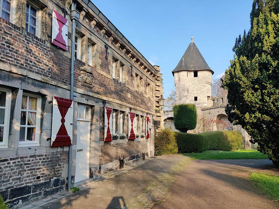 view of old buildings with red and white painted shutters and tower
