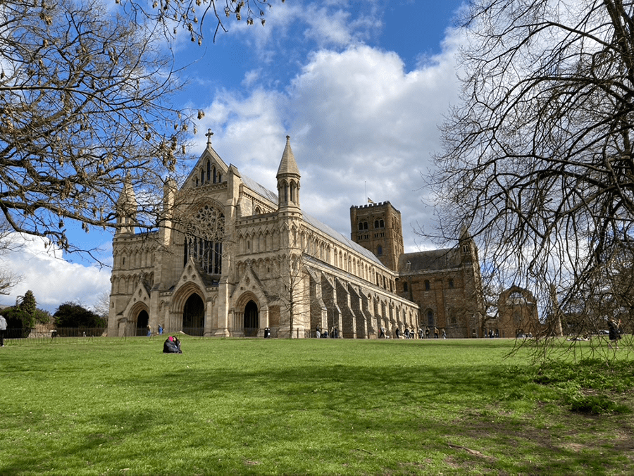 St Albans Cathedral with double buttresses and three arches entrances with stained glass windows above, one of the hidden gems in England