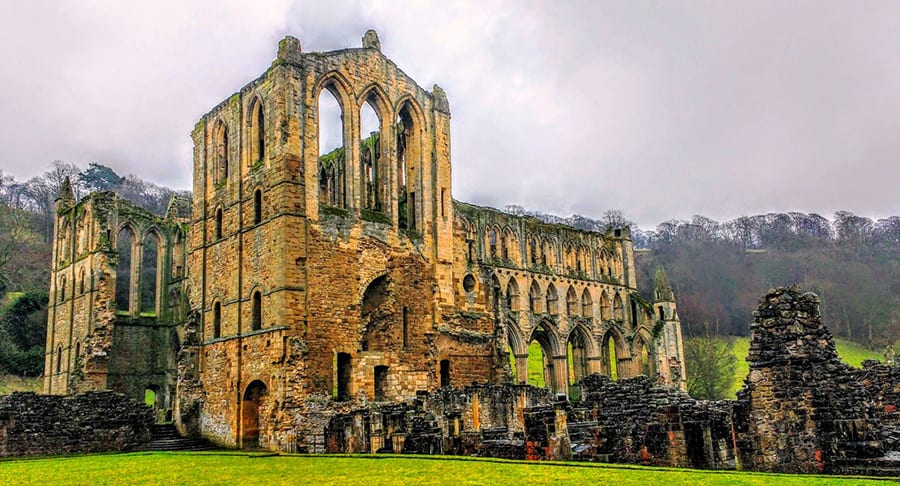 ruins of Rievaulx Abbey, a gothic abbey with arching empty windows