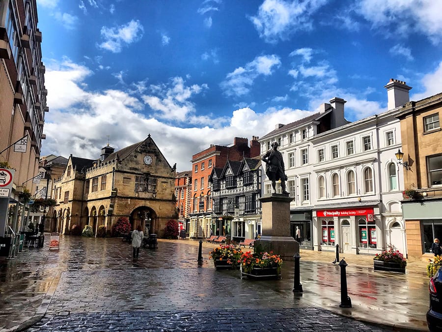 Market square in Shrewsbury with statue in the foreground and old market hall in the background