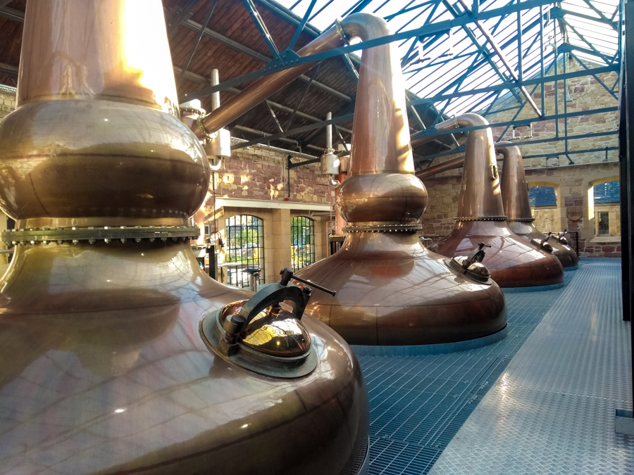 4 copper distilling vats under blue metal frames