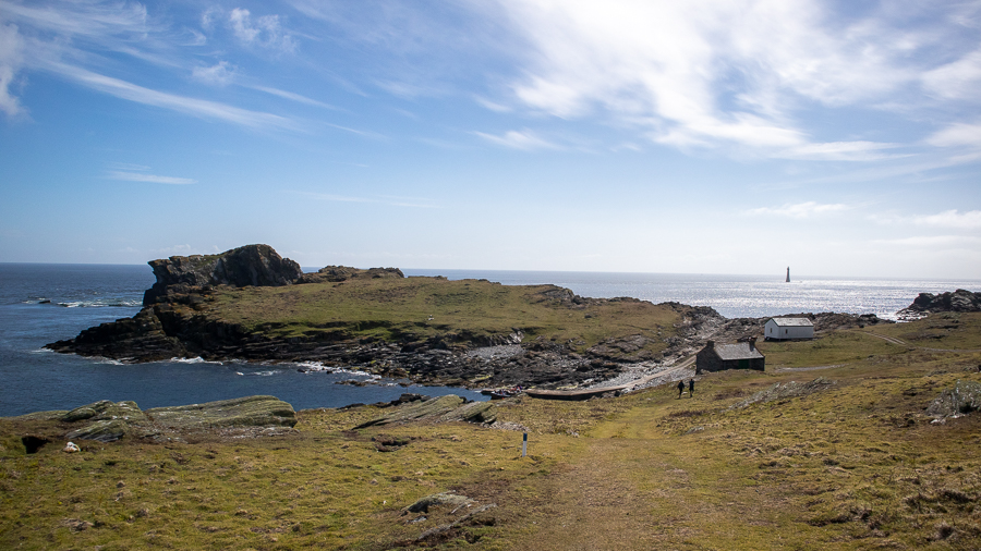 The Calf of Man with sea around it and a lighthouse in the background