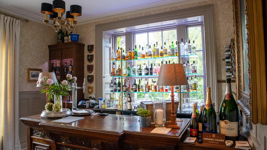 bar with bottles of alcohol on glass shelves on the window