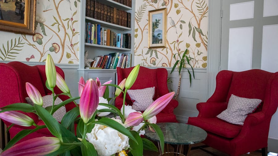 three red armchairs with pink lilies in the foreground