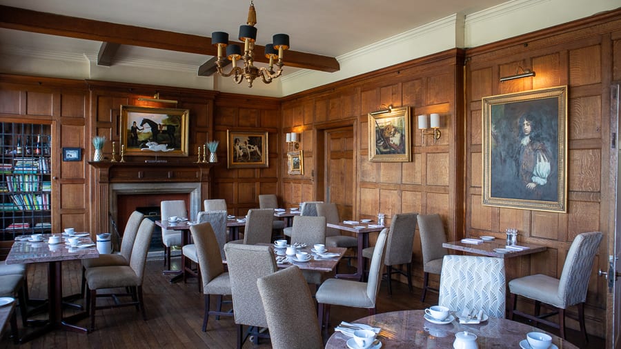 oak panelled restaurant with tables and chairs and paintings on the walls