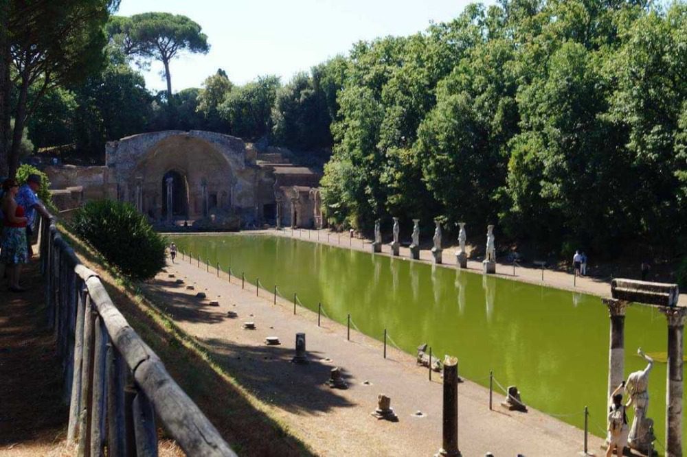 Villa Adriana Canopus - long rectangular pond with ancient statues around it and an arched building at the end