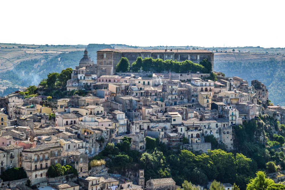Hilltop town of Ragusa with cream coloured buildings down the sides and monastery on top