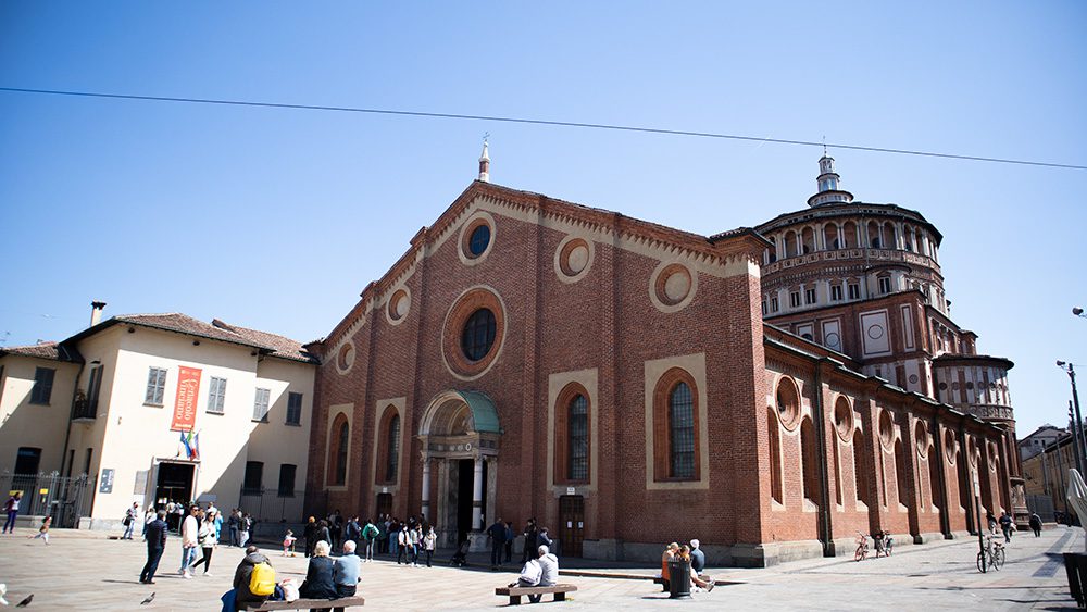 The Church of Santa Maria delle Grazie, a red brick church with a found tower to the rear one of the Unesco Heritage Sites in Italy