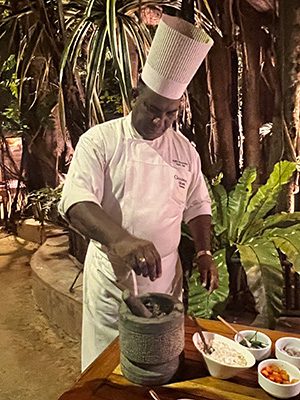 chef in whites adding spices to the sambol mix
