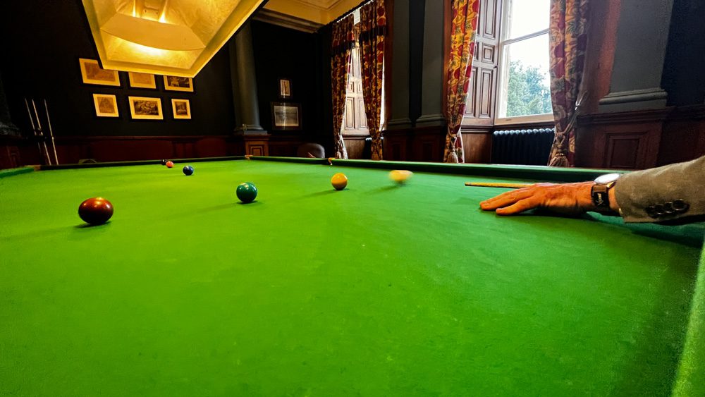 Billiards Table with a man taking a shot on the table