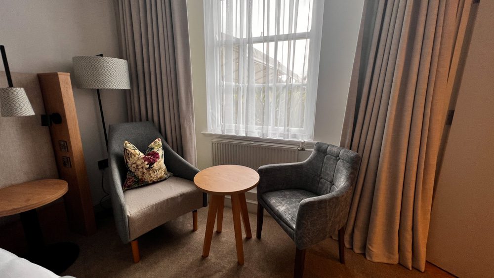 The seating in the Deluxe Room, two grey seats with round table