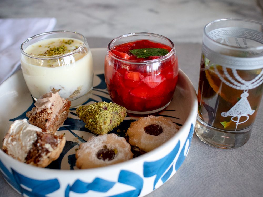 Selection of puddings in blue and white bowl with mint tea in a painted glass