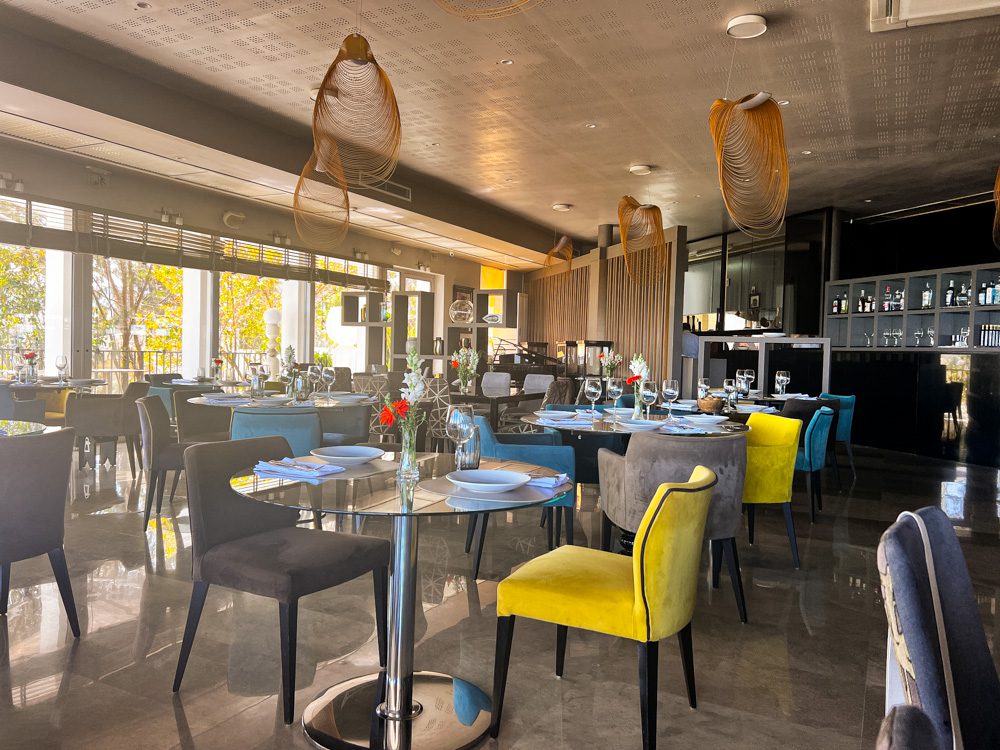 Inside the RestÔ with yellow, grey and blue chairs and glass tables
