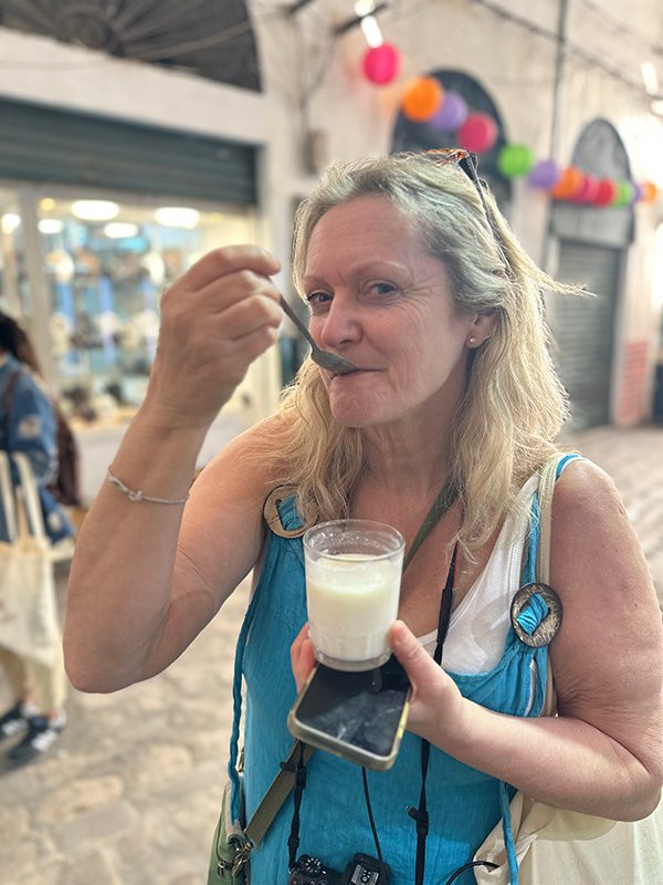 Larch in a turquoise dress trying the fermented milk