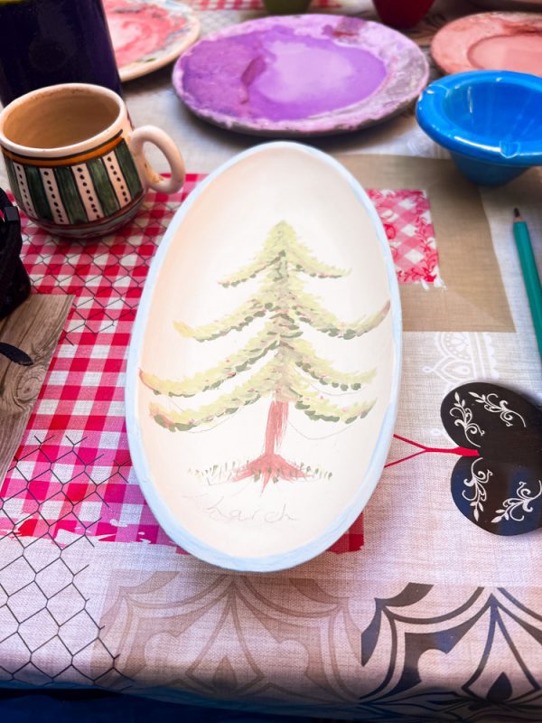 oval plater with a larch tree painted on it in greens and browns