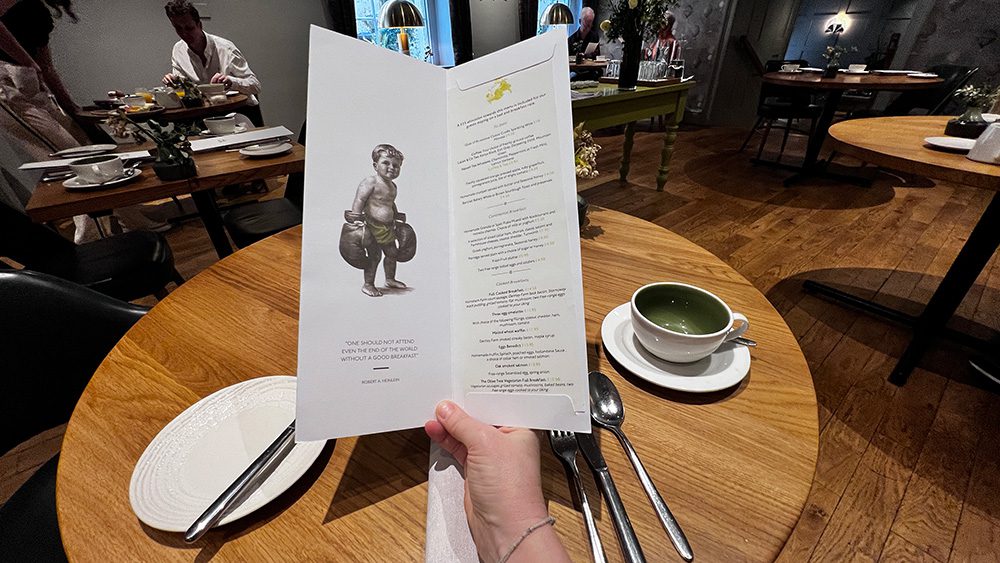 sitting at a round table looking at the menu with the list on the right and the drawn image of a young boy with boxing gloves on the left