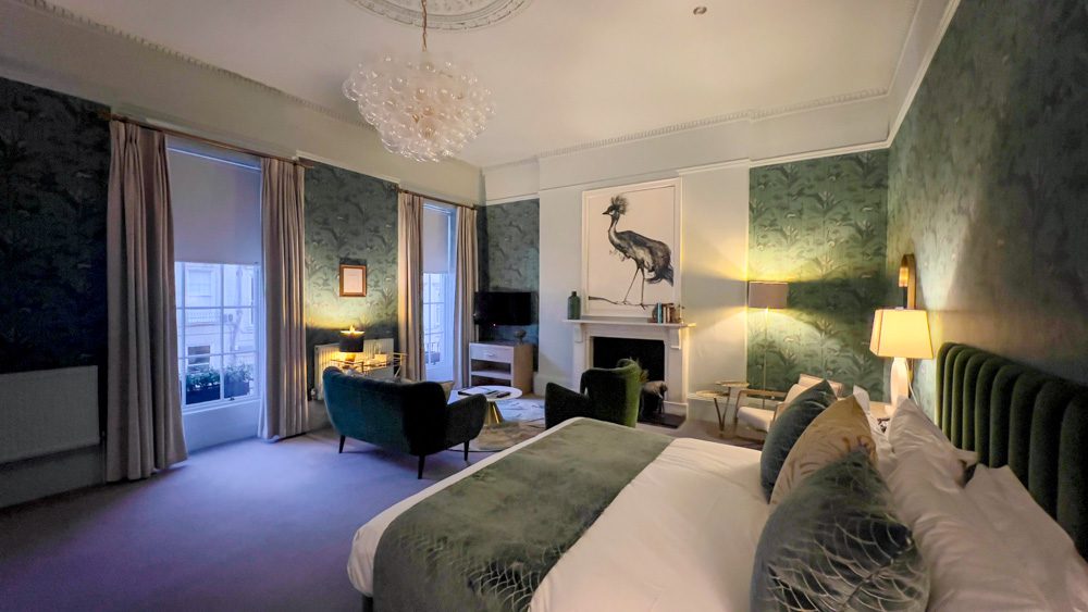 green junior suite at The Queensberry Hotel with large crested cranes painting over the fireplace