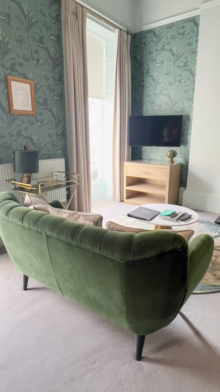 green velvet sofa in front of a television