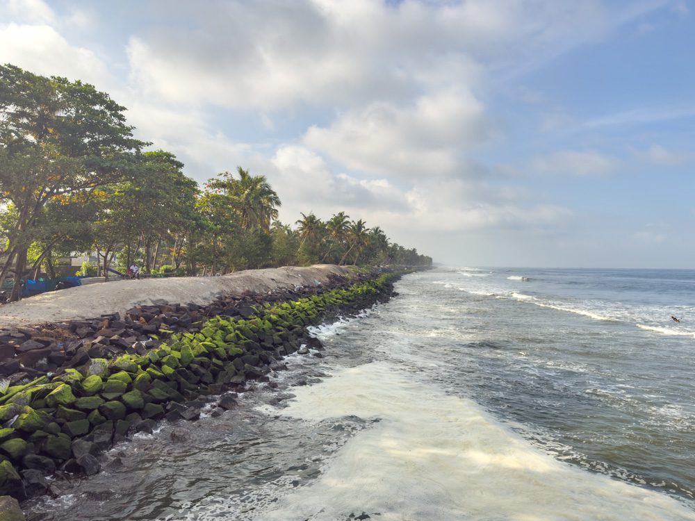 rough seas on Chellanam Beach with a built up sea wall to the left