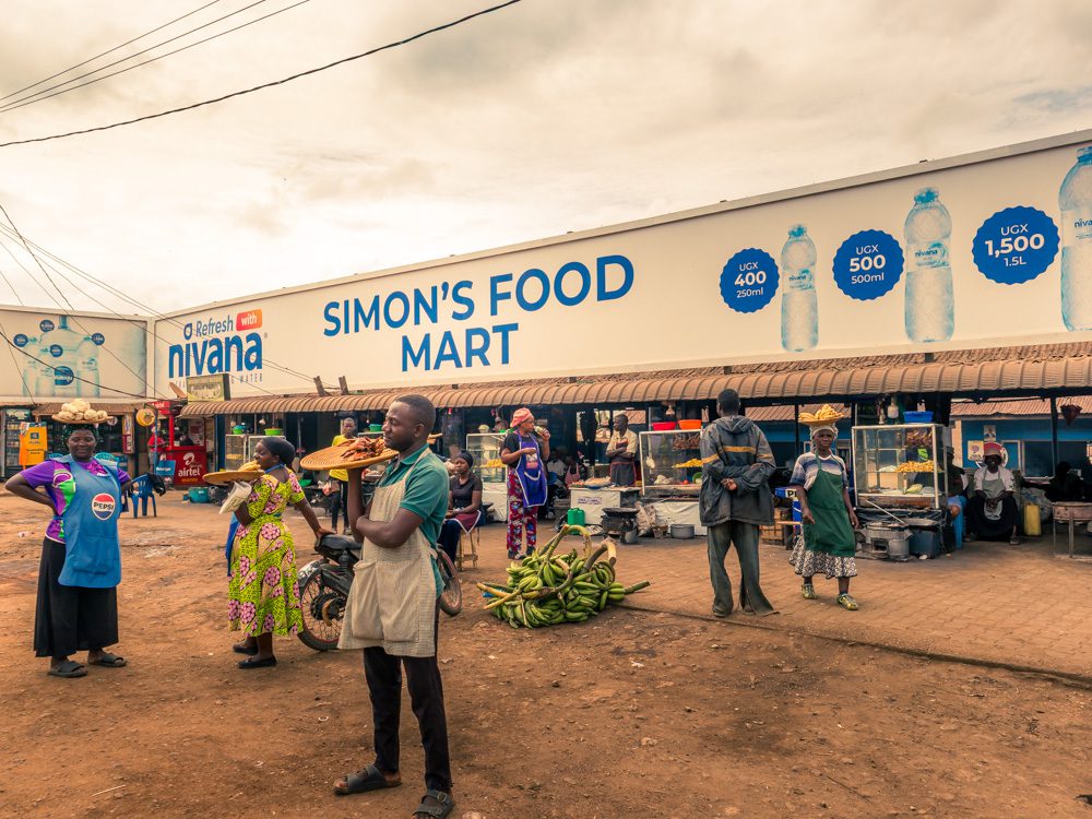 Street Market in Mubende - Simon's Food Mart with vendors holding platters of food in their hands or on their heads